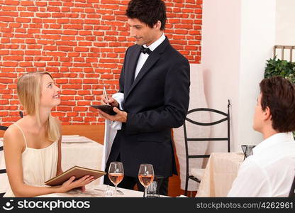 a dressy couple ordering in a chic restaurant