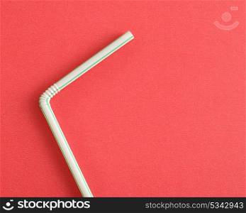 A drinking straw on a red background