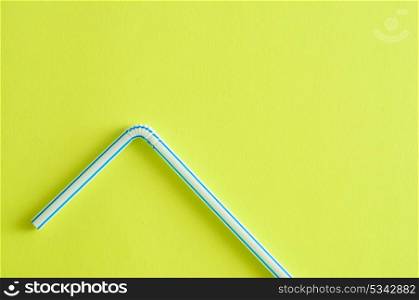 A drinking straw on a yellow background