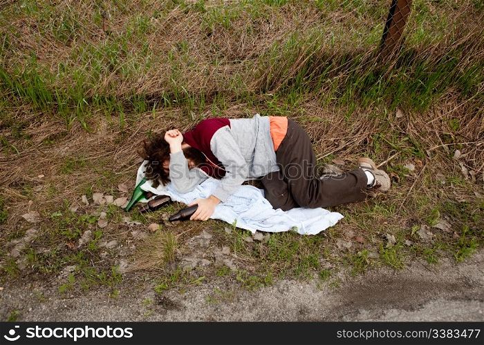 A drunk laying in the ditch with a number of bottles