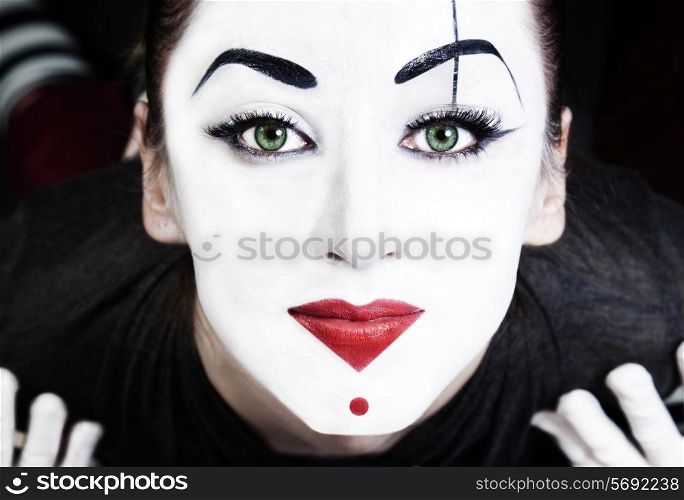 A face of beautiful woman mime with green eyes close up