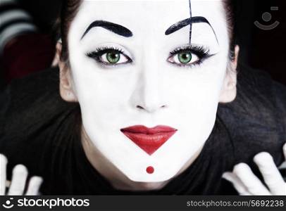 A face of beautiful woman mime with green eyes close up