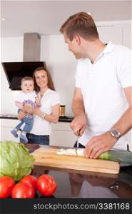 A family at home in the kitchen making a meal together, shallow depth of field, critical focus on father