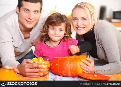 A family carving a pumpkin.