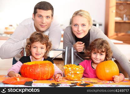 A family carving Halloween pumpkins.