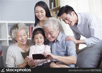 A family of five using a mobile phone