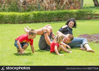 A family playing and having fun outside on the lawn of their home.