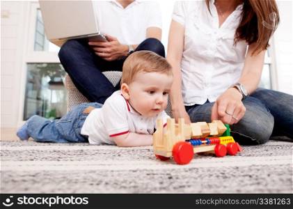 A family together in the living room, son playing on the floor