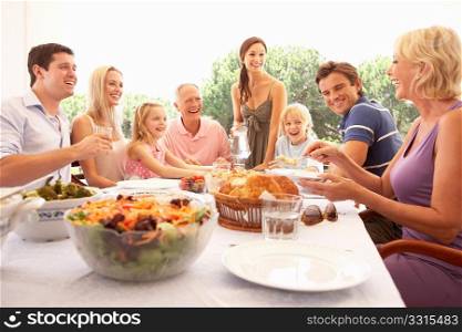 A family, with parents, children and grandparents, enjoy a picnic