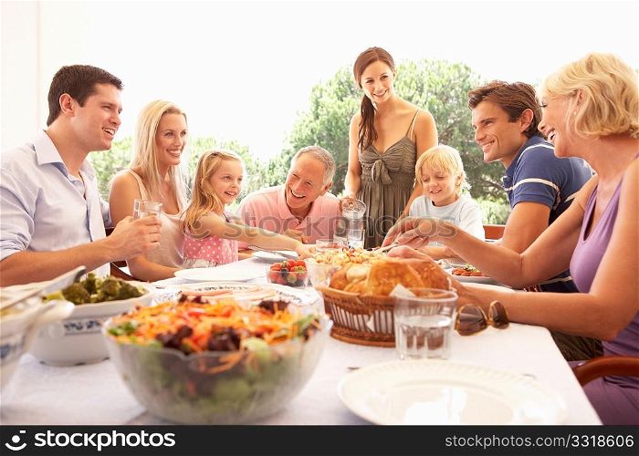 A family, with parents, children and grandparents, enjoy a picnic