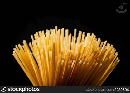 A fan of spaghetti dry on a black background. High quality photo. A fan of spaghetti dry on a black background.