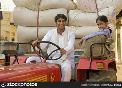 A farmer and his daughter on the tractor