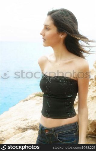 A fashionable woman poses by the coast of Malta.