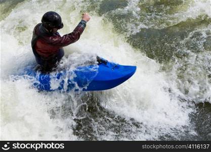 A fast shutterspeed shot of a kayaker in very rough whitewater.