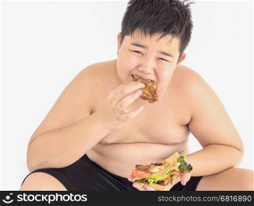 A fat boy is happily eating sandwich