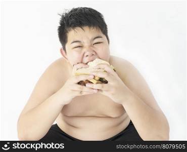 A fat boy is happily eating sandwich.