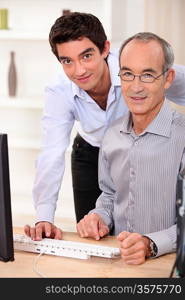 A father and his son looking at a computer.