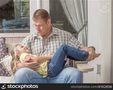 A father and young daugter spend quality time together outside on the porch of their house.