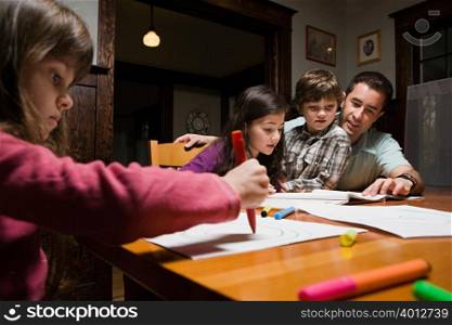 A father supervising his children with their homework
