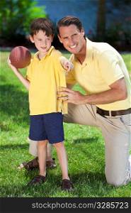 A father teaching his son how to play american football outside in sunshine