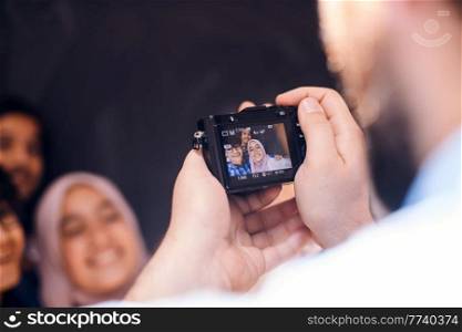 A father with a camera photographs his children as they pose with a smile on their face. High quality photo. A father with a camera photographs his children as they pose with a smile on their face