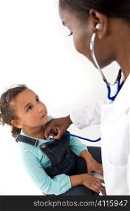 A female African American doctor using her stethoscope to examine a mixed race little girl