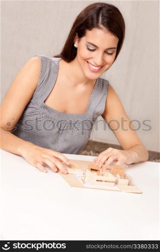 A female architect designing a scale model house