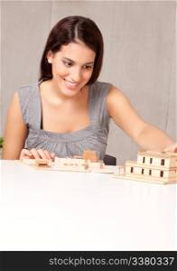 A female architect looking at a rough building model