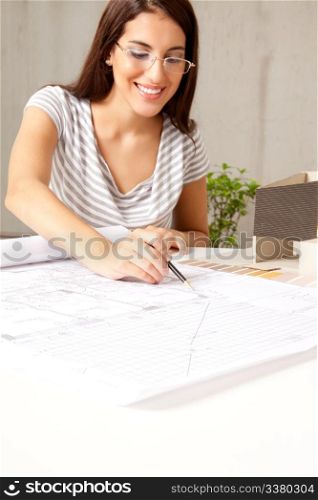A female architect looking blueprints in an office