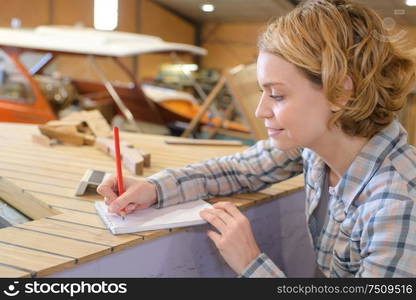 a female carpenter making notes