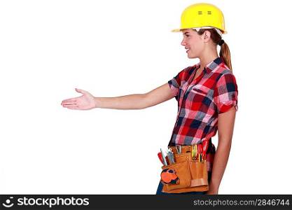 A female construction worker about to shake hands.
