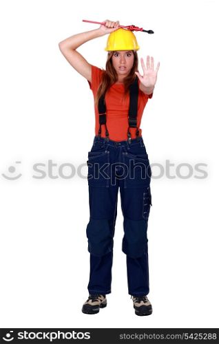 A female construction worker doing a stop sign.