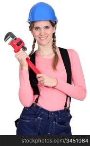 A female construction worker holding a wrench.