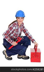 A female construction worker holding a wrench.