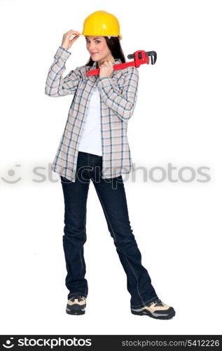 A female construction worker holding a wrench.