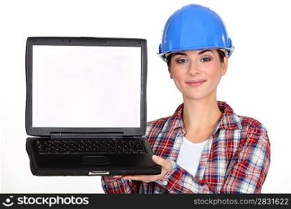 A female construction worker presenting a laptop.