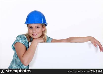 A female construction worker with a billboard.
