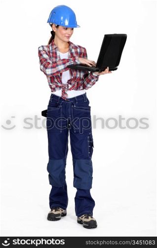 A female construction worker with a laptop.