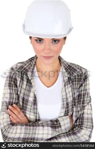 A female construction worker with their arms crossed.