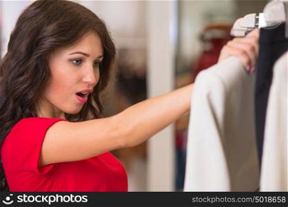 A female consumer shopping in an clothes store with joy and expression