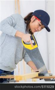 a female contractor using handsaw