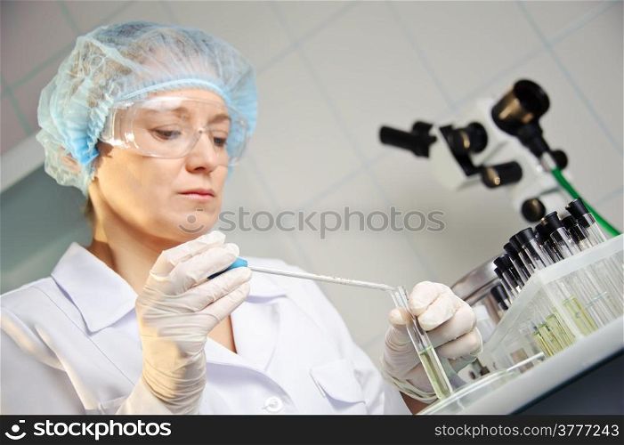 A female doctor examines a sample. Shallow depth of field. Focus on foreground, hands.&#xA;Could be useful for medicine, hospital, research and development, clinical studies, forensics, science etc