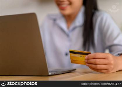 A female employee holds a credit card for online payment.