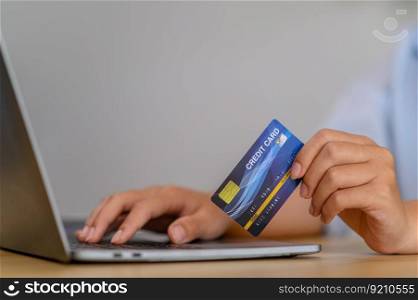 A female employee holds a credit card for online payment.