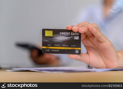 A female employee holds a credit card for online payment.