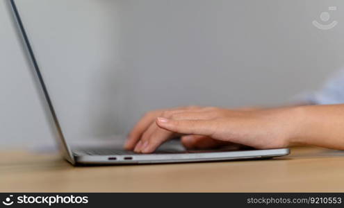 A female employee works with a laptop and holds a pen in her hand.