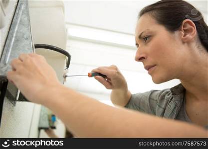 a female handyman using screwdriver