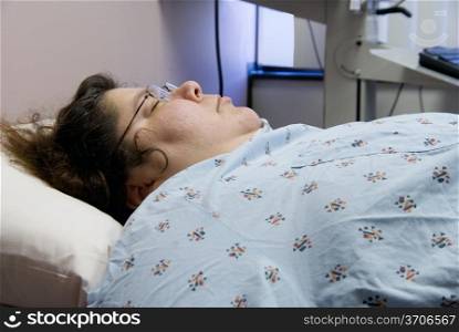 A female hospital patient laying in a bed.