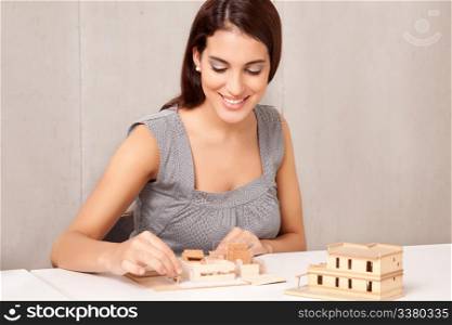 A female interior designer working on a scale model