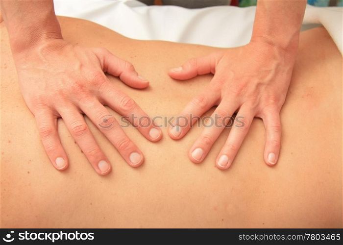 A female masseur giving a back massage